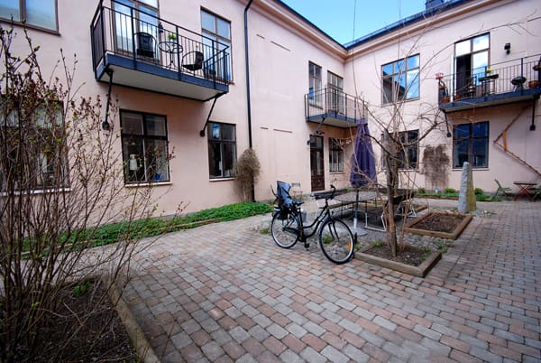 Solig och mysig innergård med sittplatser, planteringar och gårdshus med tvättstuga på Bårdskäraren 3 i Sala